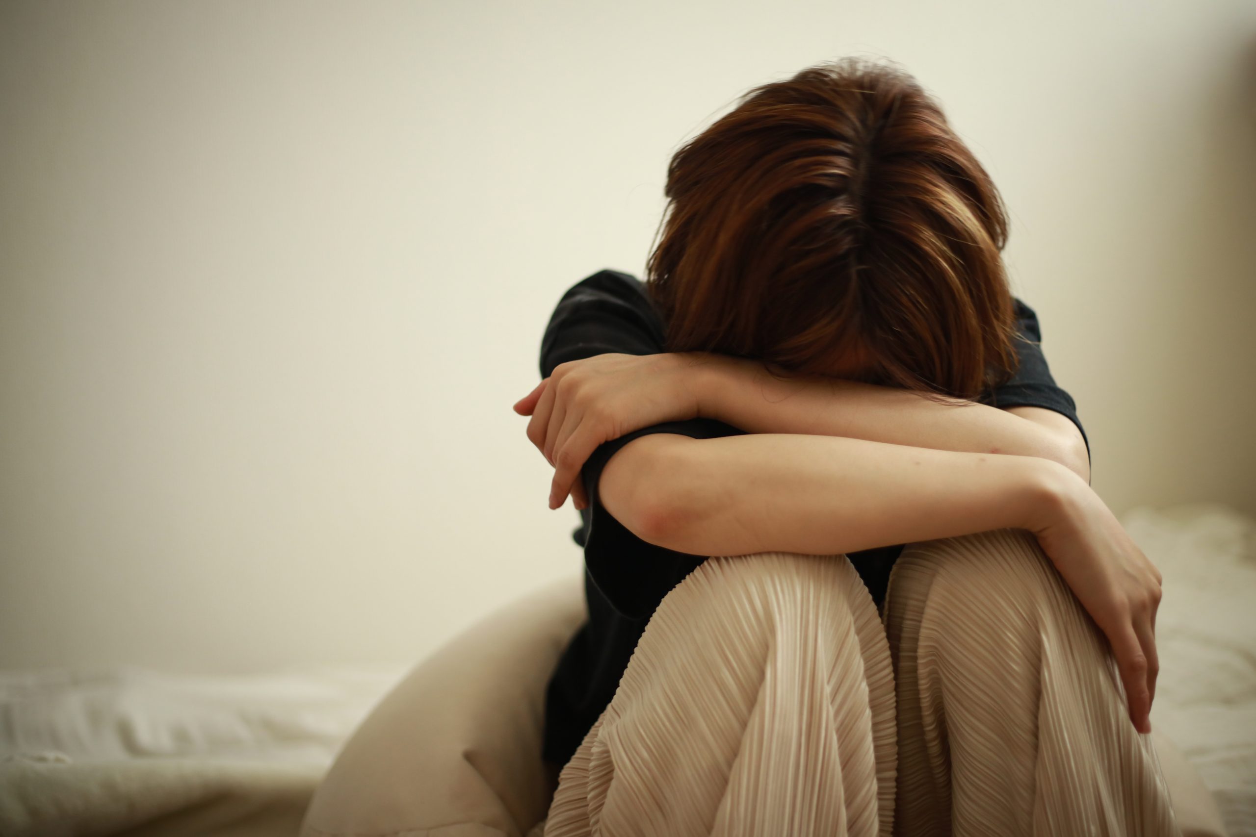 Femme assise, le regard perdu, évoquant la tristesse et l'introspection