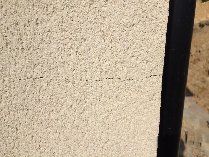 Fissure fine dans l'enduit d'un mur de maison