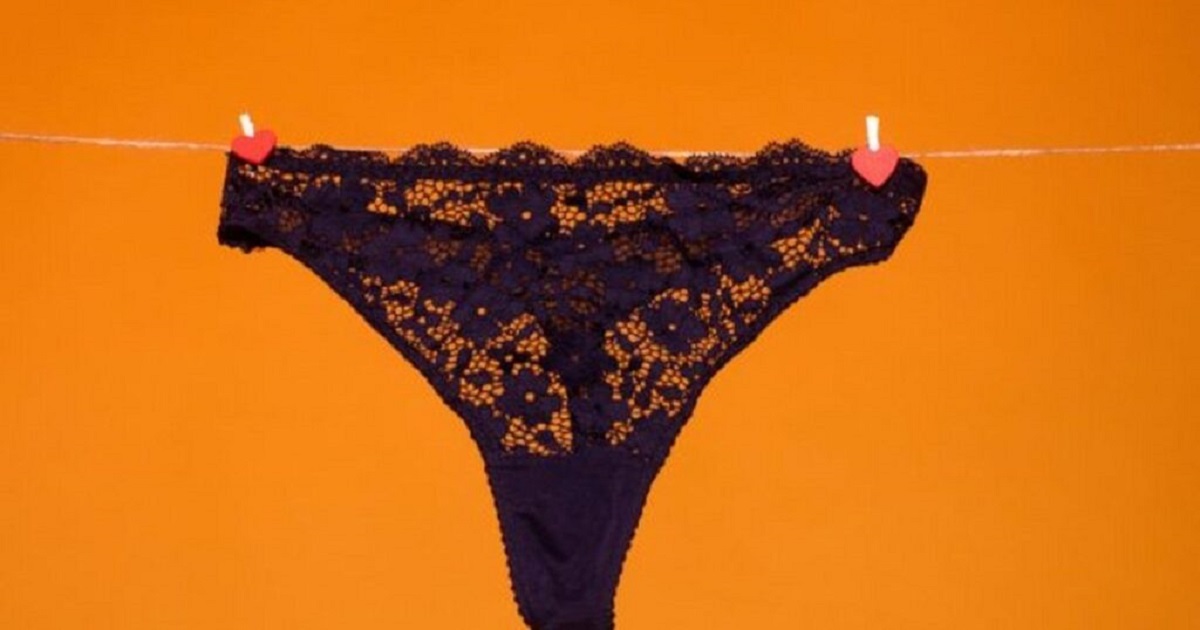 Main tenant une culotte avec un nœud, focus sur le détail