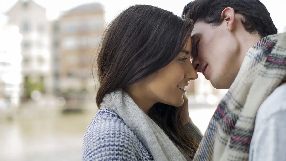 Couple souriant discutant sur un canapé