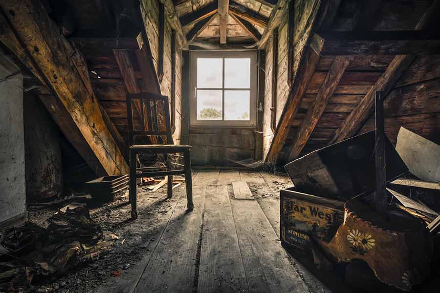 Intérieur d'un grenier ancien avec des objets recouverts de poussière