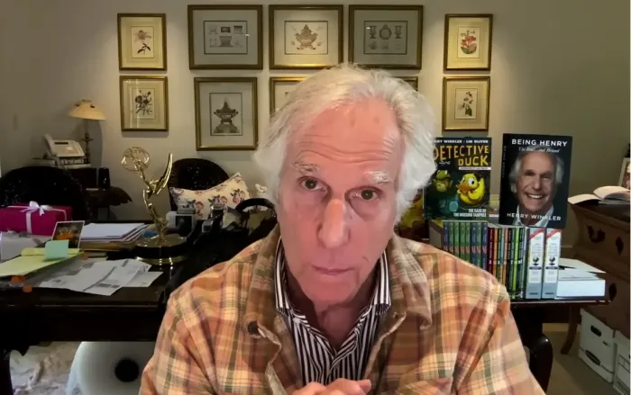 Henry Winkler signe des livres pour des enfants, souriant et bienveillant