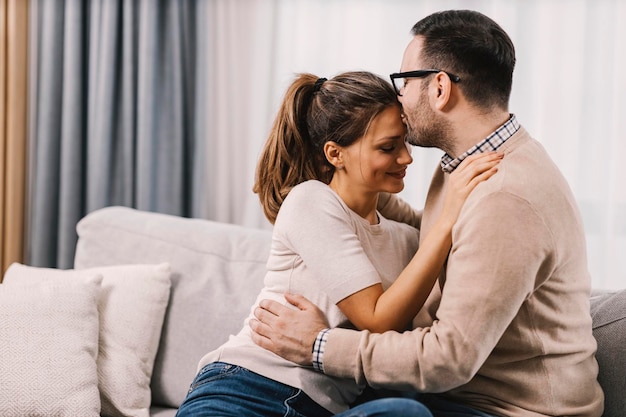 Couple échangeant un baiser rapide dans un salon