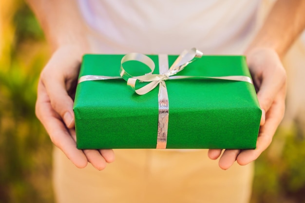 Homme tenant un cadeau avec un sourire énigmatique