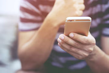 Homme utilisant son smartphone avec méfiance