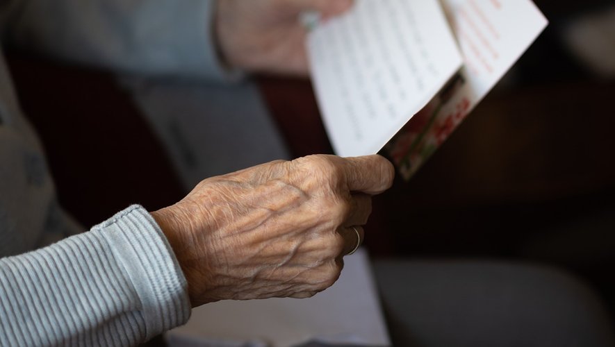 Une main tenant une lettre manuscrite sur du papier vieilli