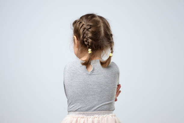 Enfant chuchotant à l'oreille d'un adulte