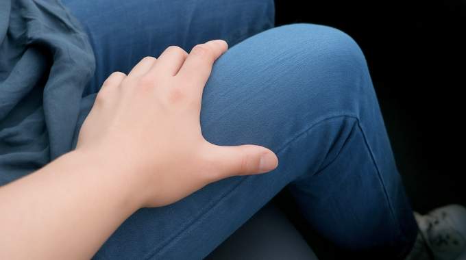 Une main masculine se pose doucement sur la jambe d'une femme lors d'un dîner
