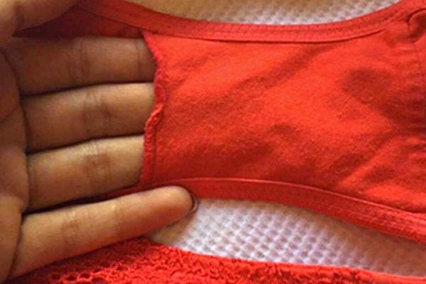 Main pointant la poche intérieure d'une culotte