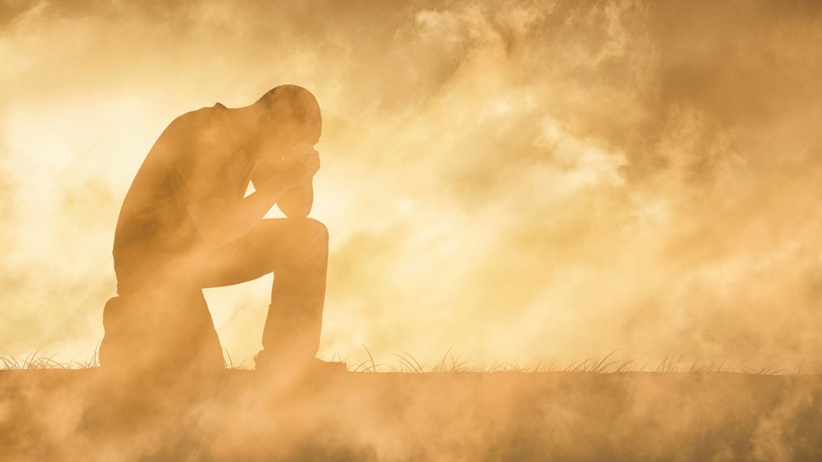 Silhouette d'une personne contemplant un paysage brumeux et dramatique, symbolisant l'épreuve et la résilience.