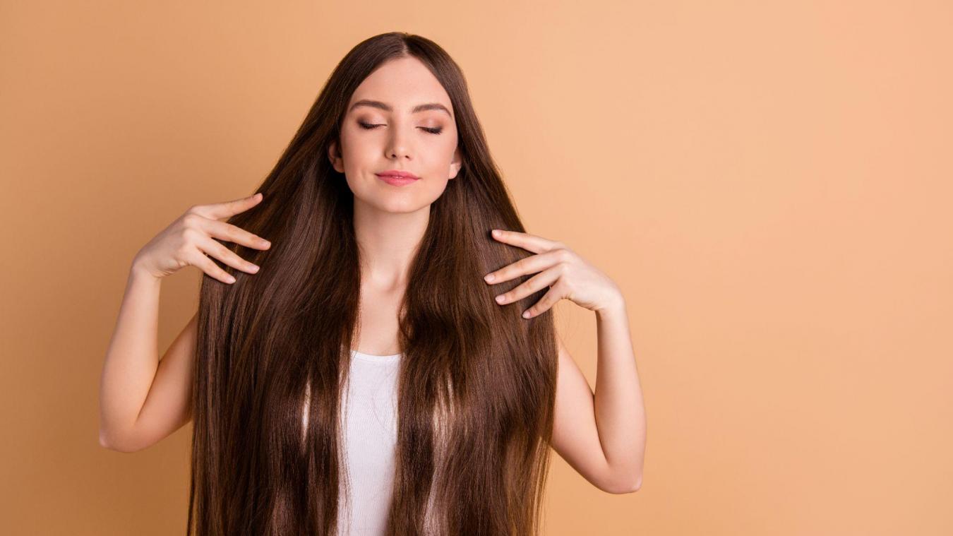Main féminine tenant un œuf dur près du visage, symbolisant beauté et nutrition