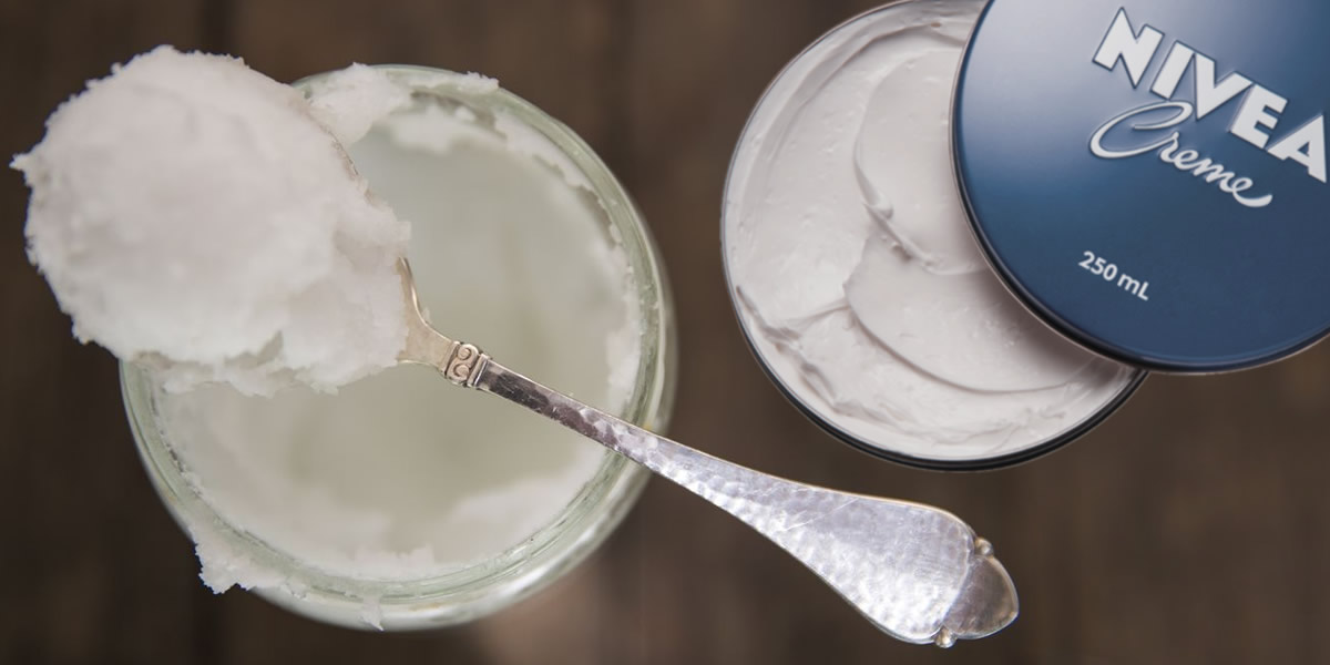 Huile de coco et crème Nivea posées sur une table en bois