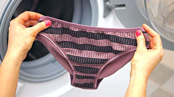 Femme réfléchissant devant un tiroir à lingerie