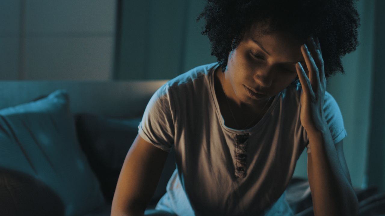 Femme se réveillant la nuit, regardant l'heure sur son réveil avec douceur