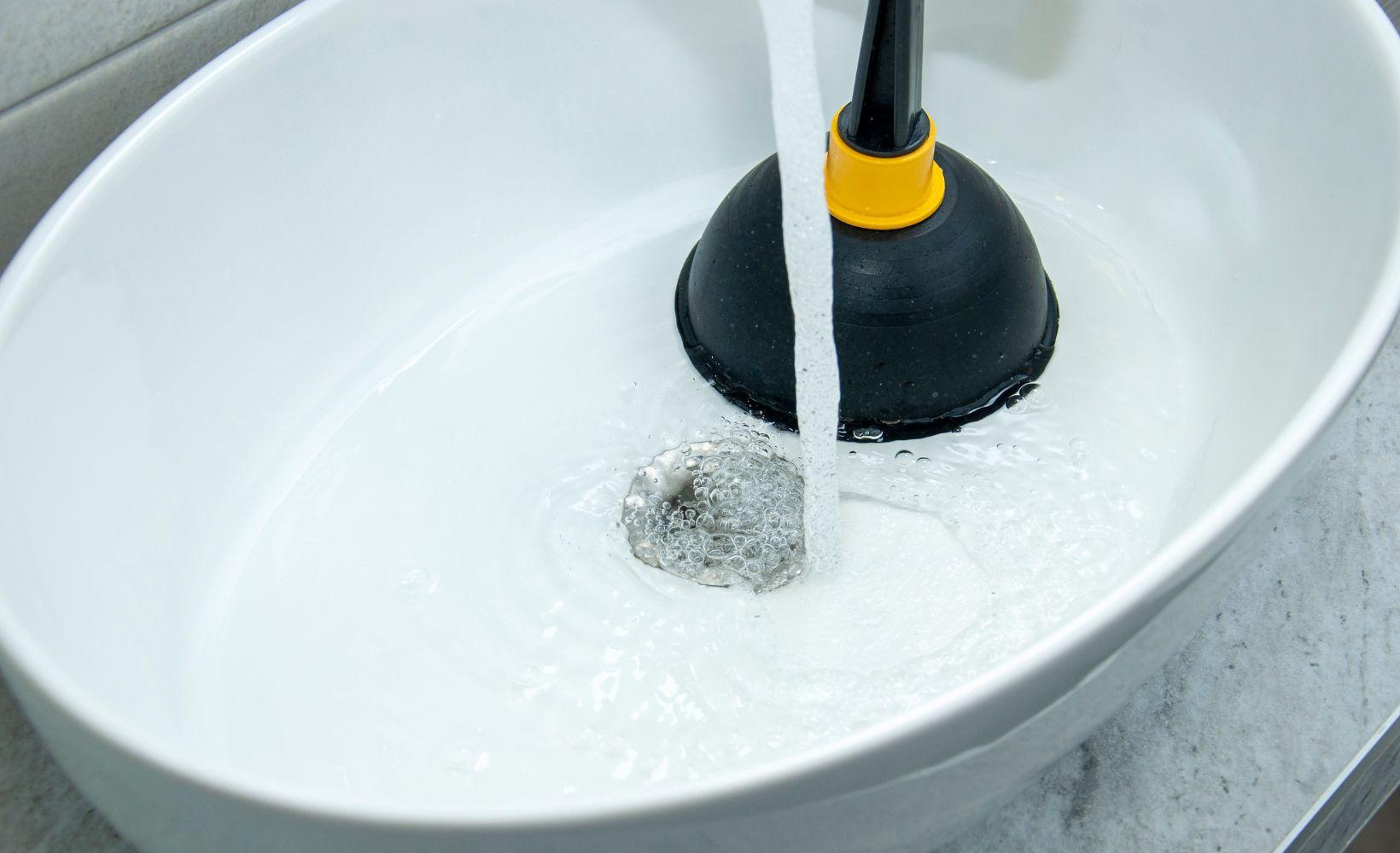 Utilisation d'une ventouse pour déboucher un lavabo