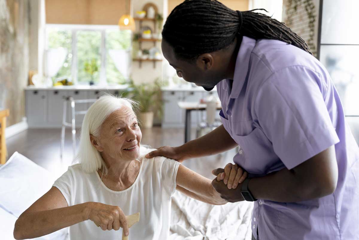 Une personne âgée regarde par la fenêtre d'un établissement, l'expression est pensive.
