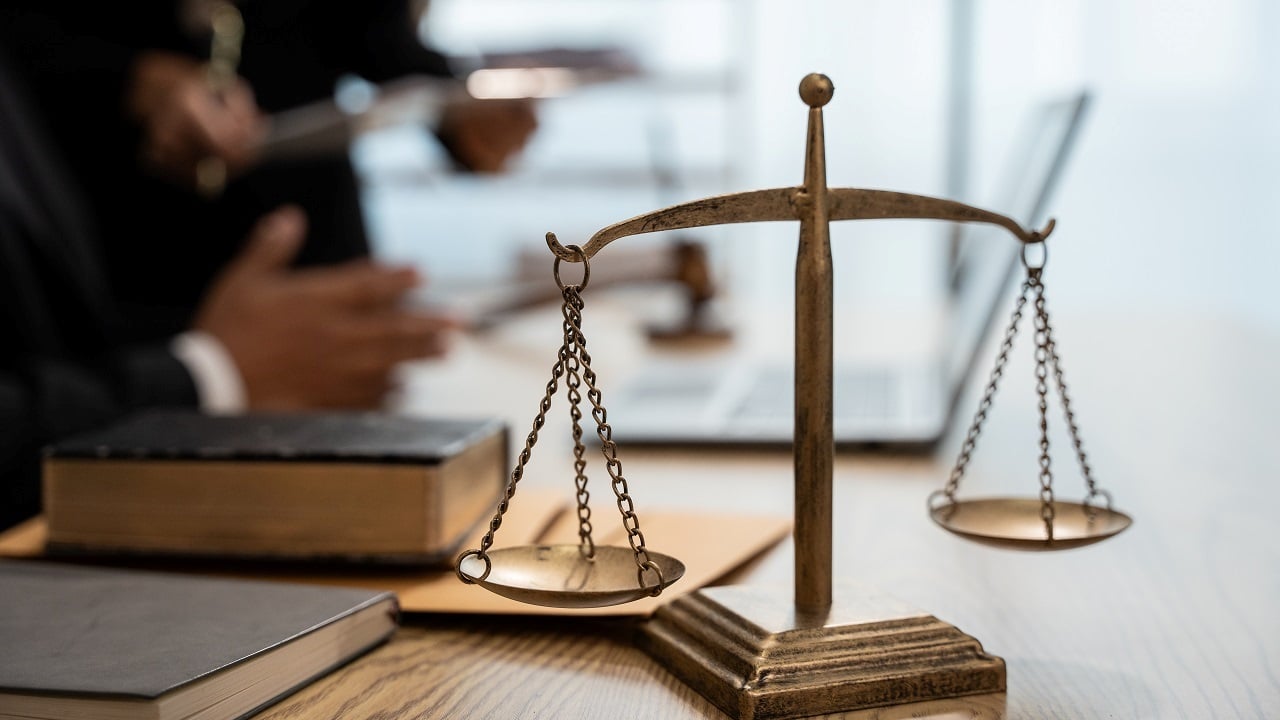 Un avocat et une cliente discutant de documents juridiques, symbole de conseil et de protection légale.