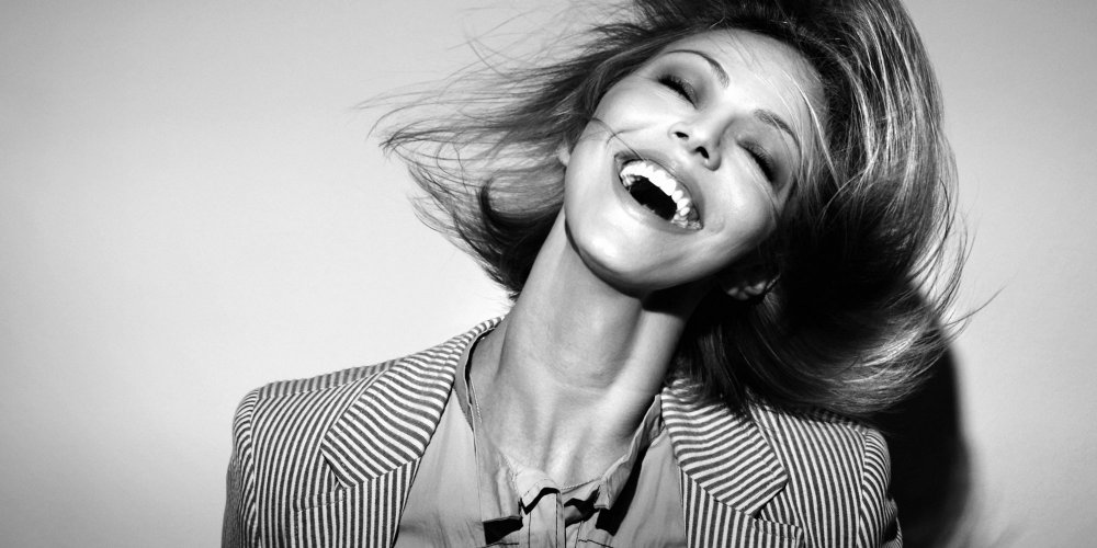 Jeune femme riant aux éclats, illustrant les bienfaits de l'humour