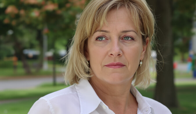 Femme regardant par la fenêtre, expression pensive