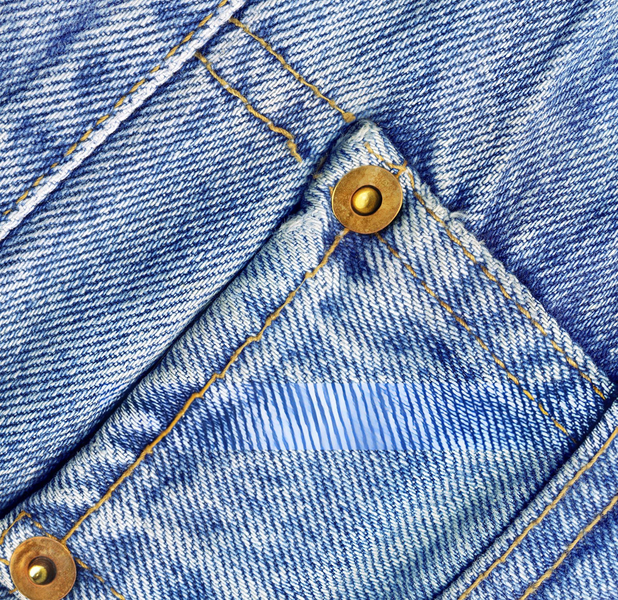 Détail des boutons d'ourlet sur un jean bootcut
