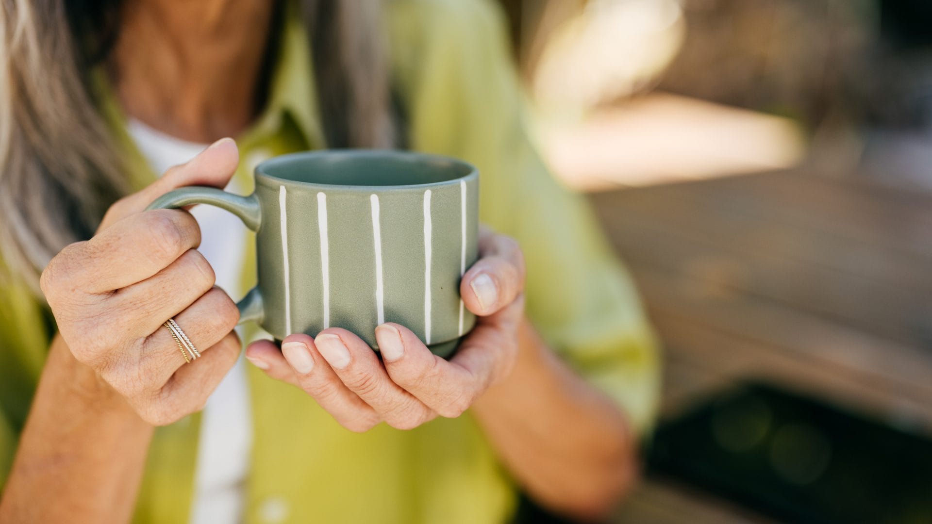 Tasse de thé et tasse de café côte à côte, avec des graines de café et des feuilles de thé