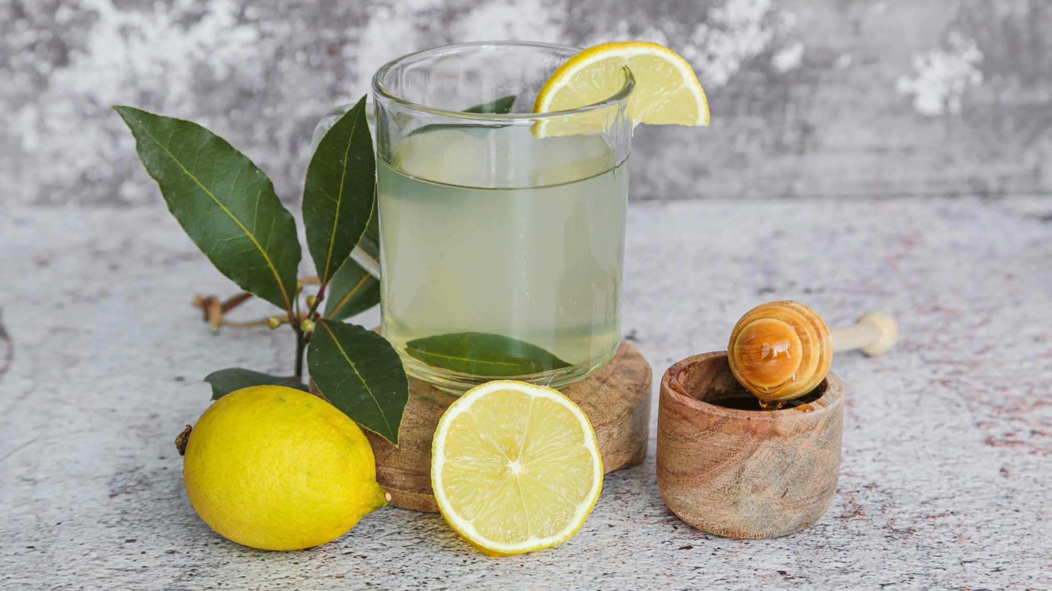 Ingrédients pour une tisane au laurier : feuilles, citron, orange, miel