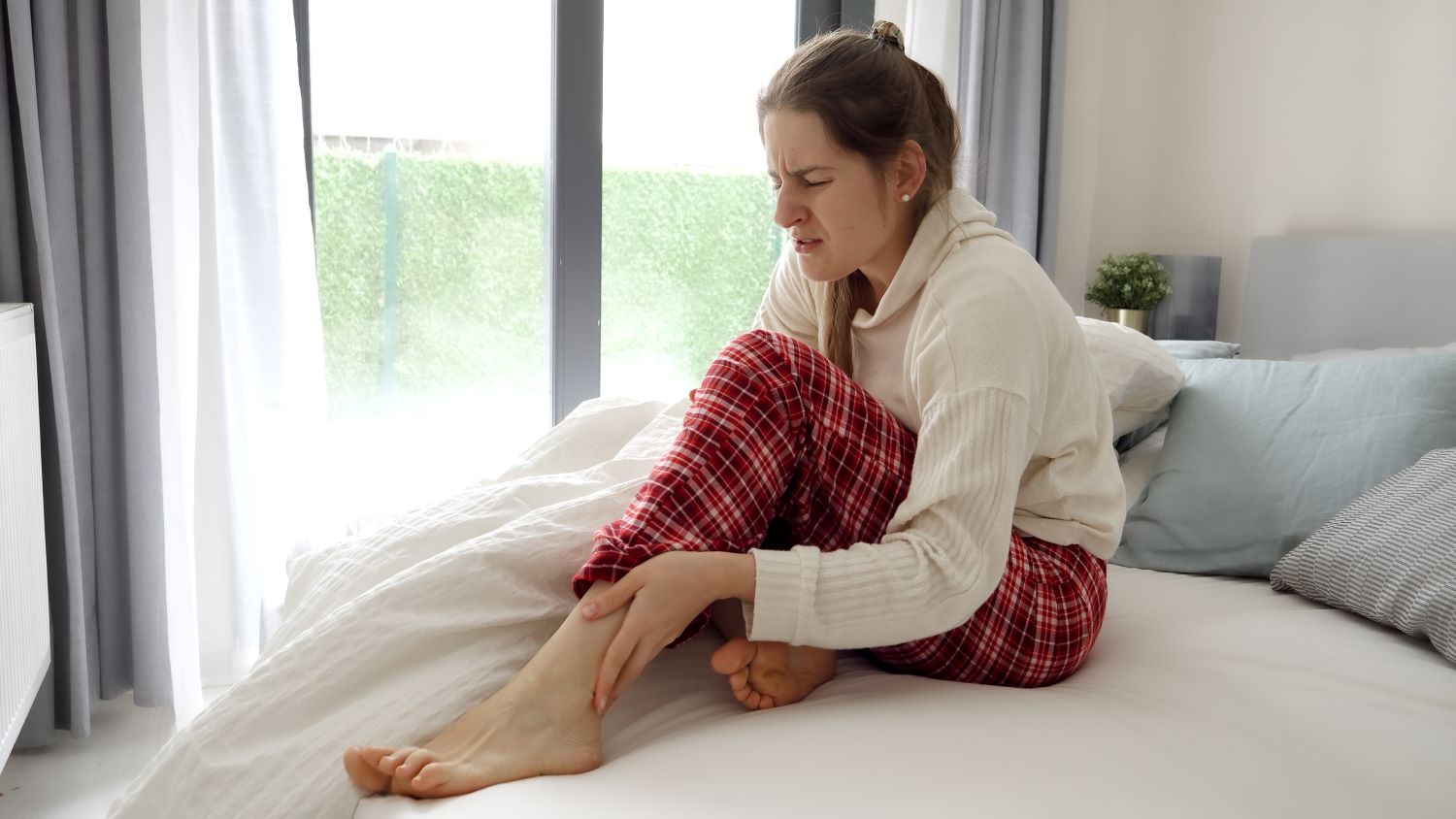 Femme se réveillant avec une crampe au mollet la nuit