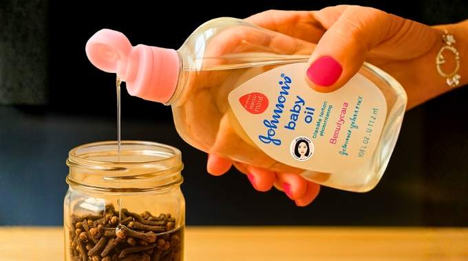 Flacon d'huile et clous de girofle sur un tissu