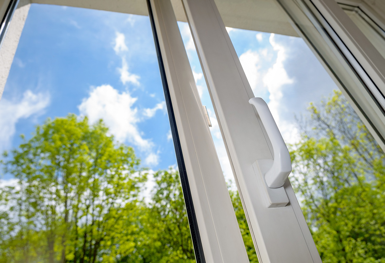 Femme nettoyant une grande vitre avec une raclette