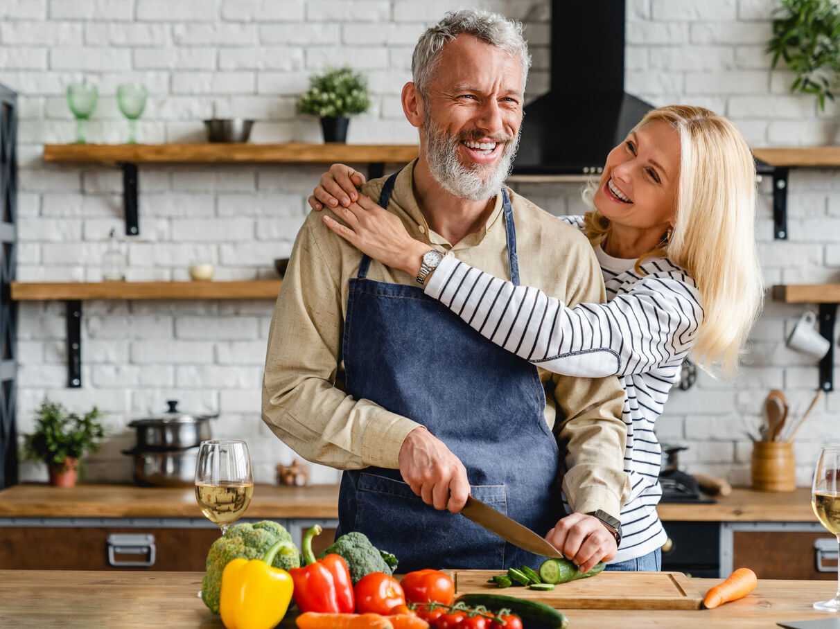 Femme souriante préparant un repas sain dans une cuisine lumineuse