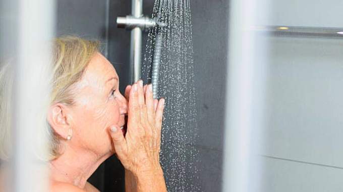 Femme réfléchissant sous la douche