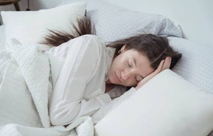 Femme relaxée dans son lit, préparant son sommeil