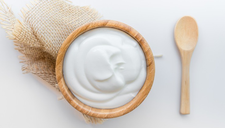 Pot de yaourt grec nature et une cuillère